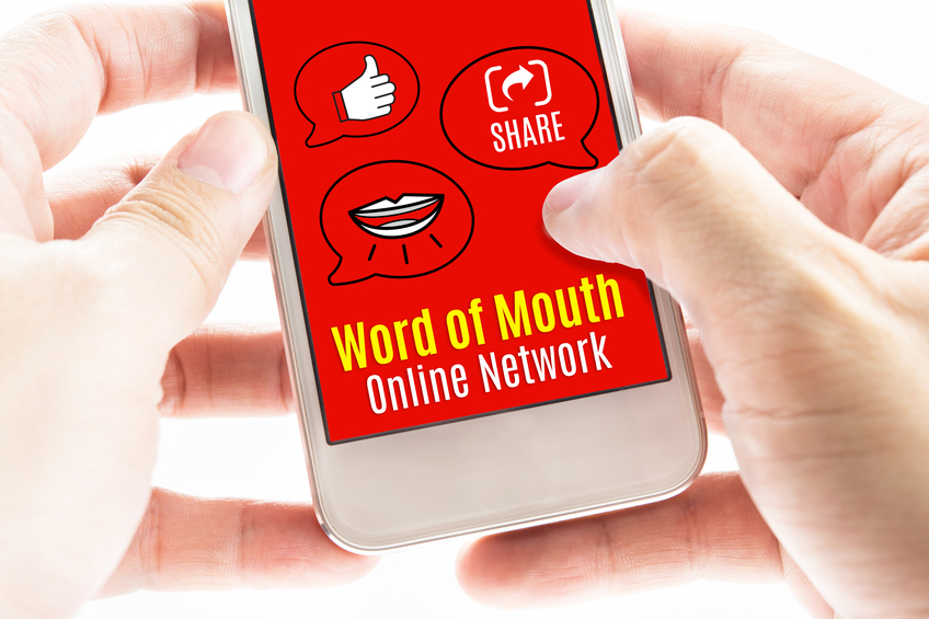 Close up Two hand holding smart phone with word of mouth online network word and icons, Digital concept.